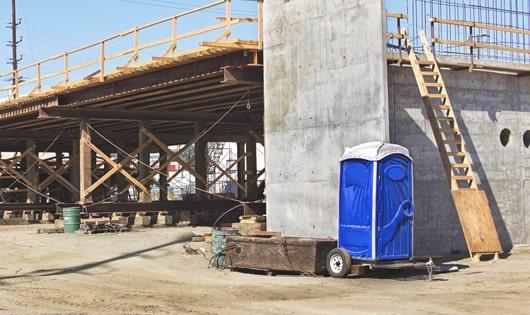 portable restrooms stacked at a busy work site